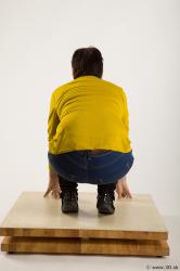 Kneeling reference of yellow sweater blue jeans Gwendolyn